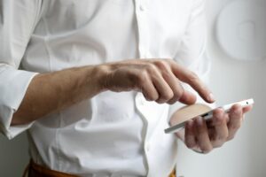 man typing on his smartphone searching for primary healthtech companies